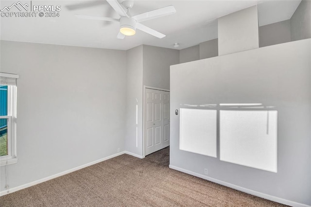 carpeted spare room featuring ceiling fan