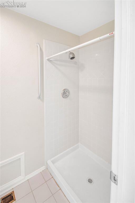 bathroom featuring tile patterned flooring and tiled shower