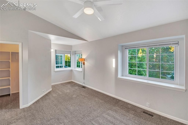 empty room with ceiling fan, vaulted ceiling, and carpet