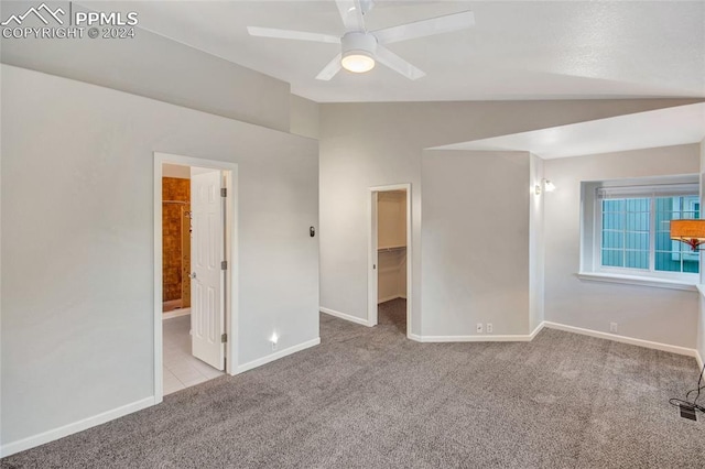 carpeted spare room with lofted ceiling and ceiling fan