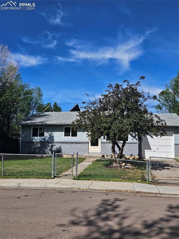 view of front of property with a front lawn, a fenced front yard, and a gate