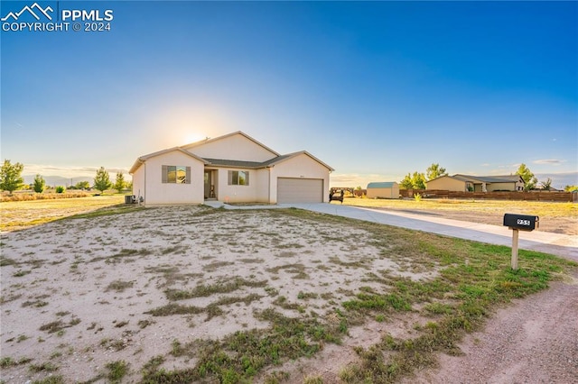 ranch-style home with a garage and central AC unit