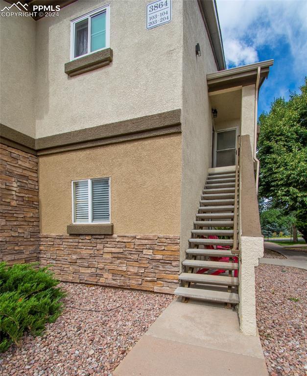 exterior space featuring stone siding and stucco siding