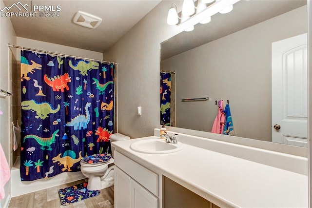 full bathroom with toilet, hardwood / wood-style floors, vanity, and shower / tub combo