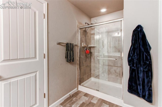 bathroom featuring hardwood / wood-style floors and a shower with door