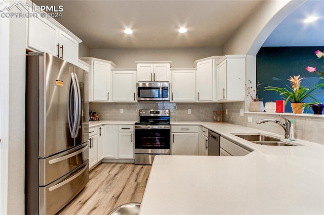 kitchen featuring sink, white cabinetry, light hardwood / wood-style flooring, and appliances with stainless steel finishes