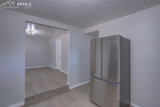 kitchen with light hardwood / wood-style flooring and stainless steel fridge