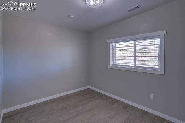 unfurnished room featuring vaulted ceiling and wood-type flooring