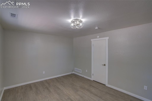 spare room with hardwood / wood-style flooring and a textured ceiling