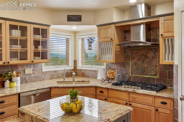 kitchen featuring stainless steel appliances, light stone counters, wall chimney exhaust hood, and tasteful backsplash