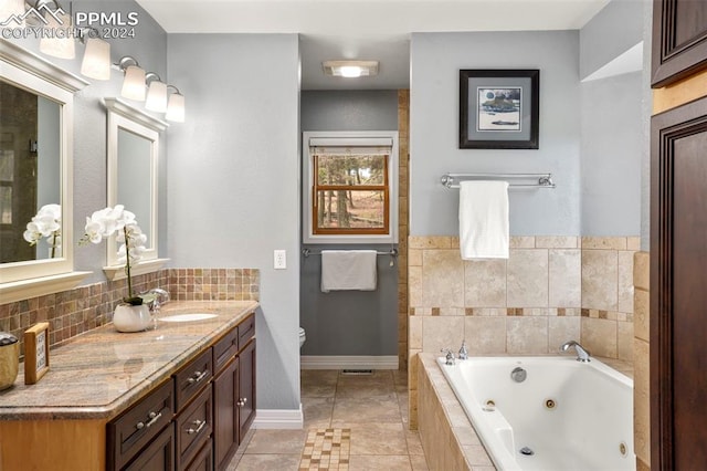 bathroom with toilet, tile patterned flooring, tiled tub, and vanity