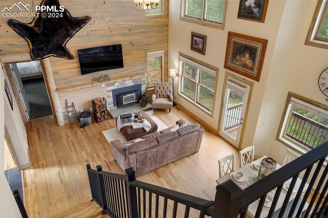 living room with wood walls, light hardwood / wood-style flooring, and a high ceiling