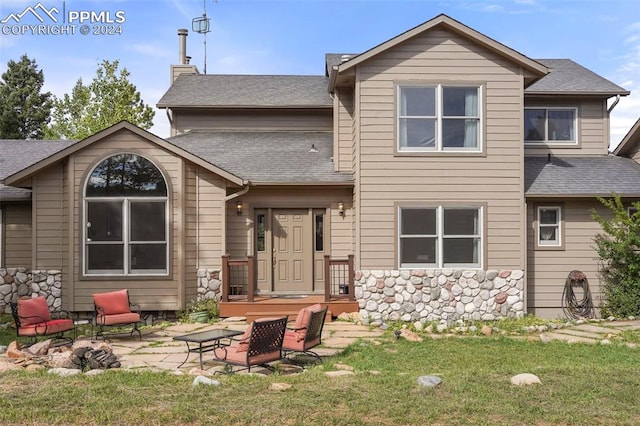 rear view of property featuring a patio area and a yard