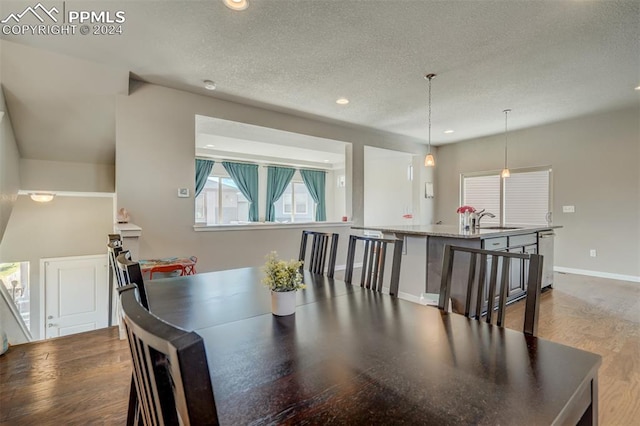 dining area with hardwood / wood-style flooring, a textured ceiling, and sink