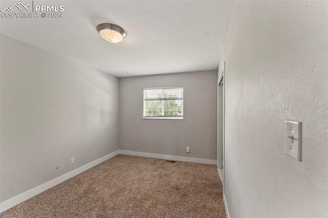 unfurnished room featuring carpet flooring and baseboards