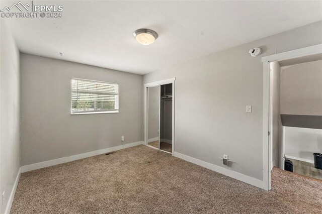 unfurnished bedroom with a closet and carpet flooring