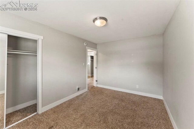 unfurnished bedroom with a closet and carpet floors