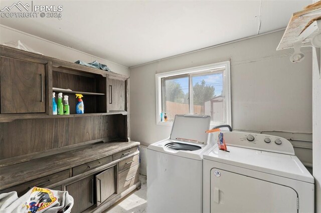 clothes washing area with cabinets and independent washer and dryer