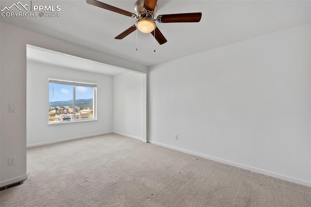 carpeted spare room with ceiling fan