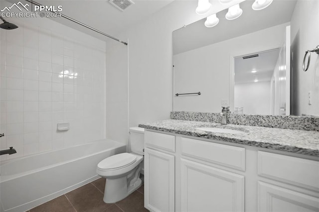 full bathroom with tile patterned flooring, vanity, tiled shower / bath combo, and toilet