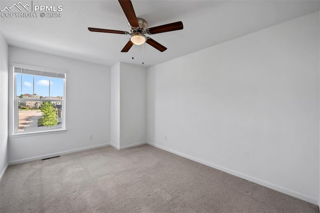 carpeted spare room with ceiling fan