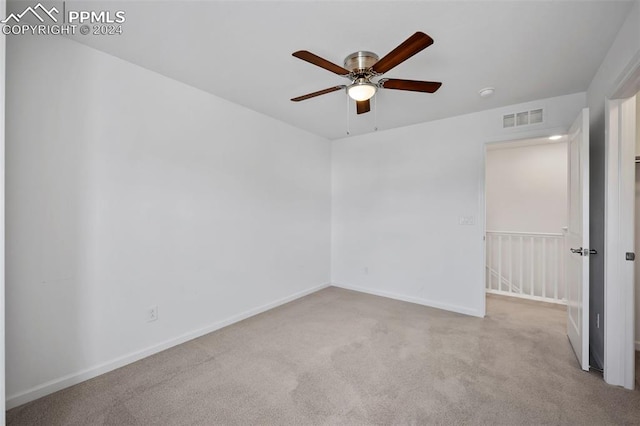 empty room with light colored carpet and ceiling fan