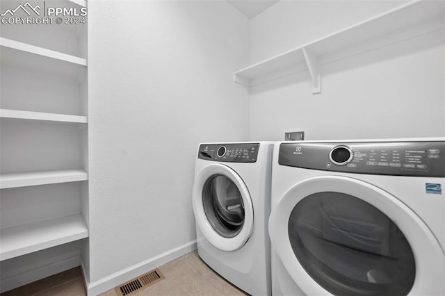 laundry area featuring separate washer and dryer and light tile patterned floors