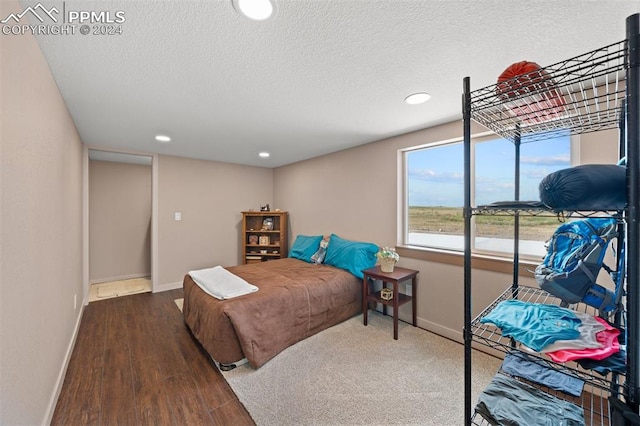 bedroom with hardwood / wood-style flooring and a textured ceiling