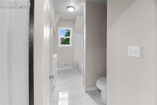 bathroom with tile patterned floors, toilet, a textured ceiling, and vanity