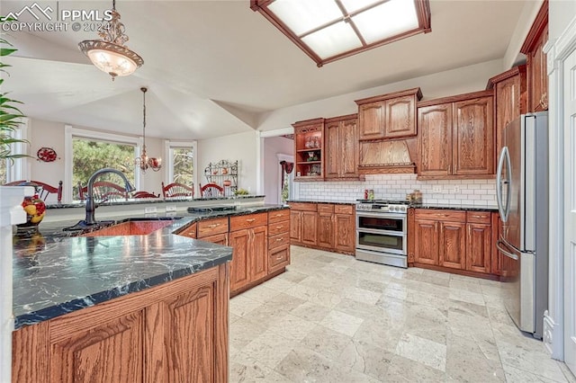 kitchen with backsplash, sink, hanging light fixtures, appliances with stainless steel finishes, and lofted ceiling