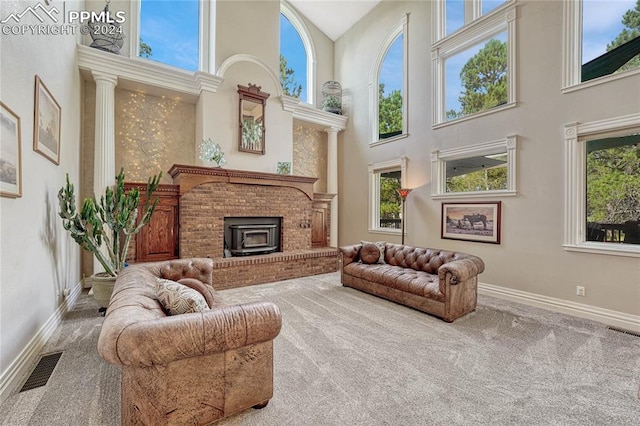 carpeted living room featuring a towering ceiling and a fireplace