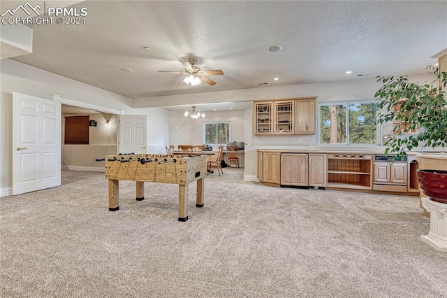 playroom with ceiling fan with notable chandelier, light colored carpet, and a textured ceiling