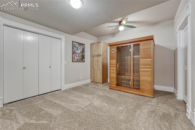 unfurnished bedroom featuring a textured ceiling, ceiling fan, and light carpet