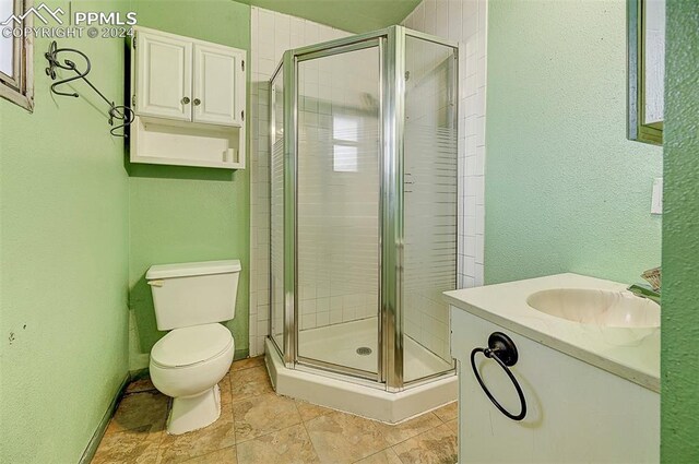 bathroom with tile patterned floors, toilet, walk in shower, and vanity