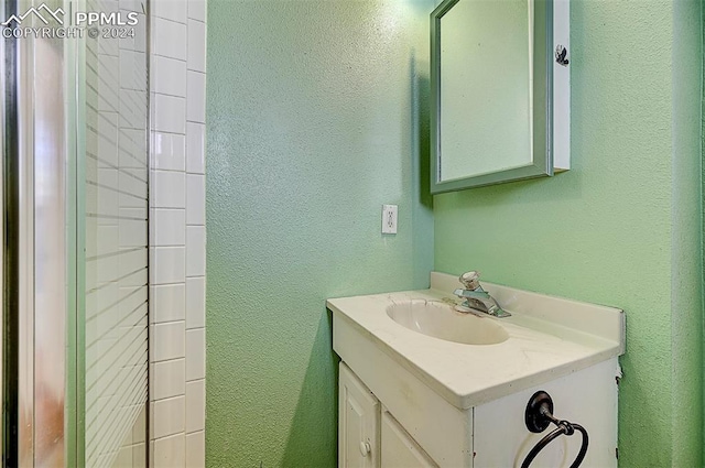 bathroom featuring a textured wall and vanity