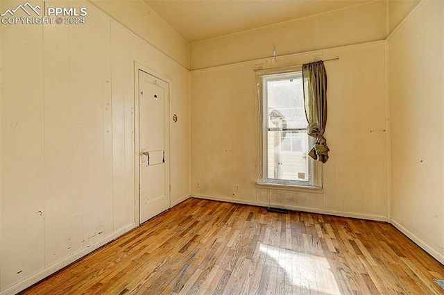 spare room with wood-type flooring and baseboards