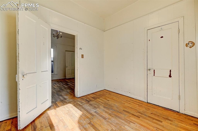 unfurnished room featuring hardwood / wood-style floors and an inviting chandelier