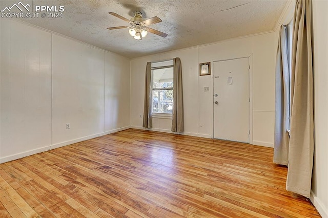 foyer with light wood-type flooring, a textured ceiling, and ceiling fan