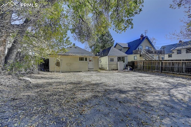 back of property with fence and an outdoor structure