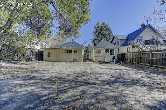 rear view of property featuring a fenced backyard and an outdoor structure