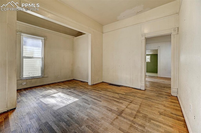 spare room with wood finished floors and visible vents