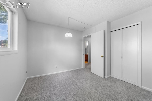 unfurnished bedroom with a textured ceiling and carpet floors