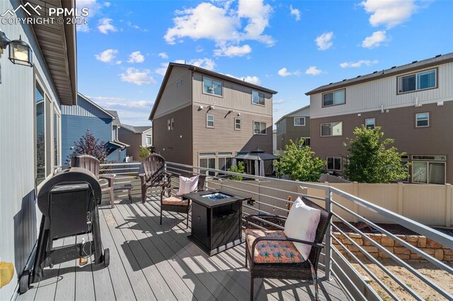 deck featuring an outdoor living space with a fire pit