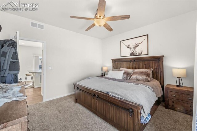 bedroom with ceiling fan and light colored carpet