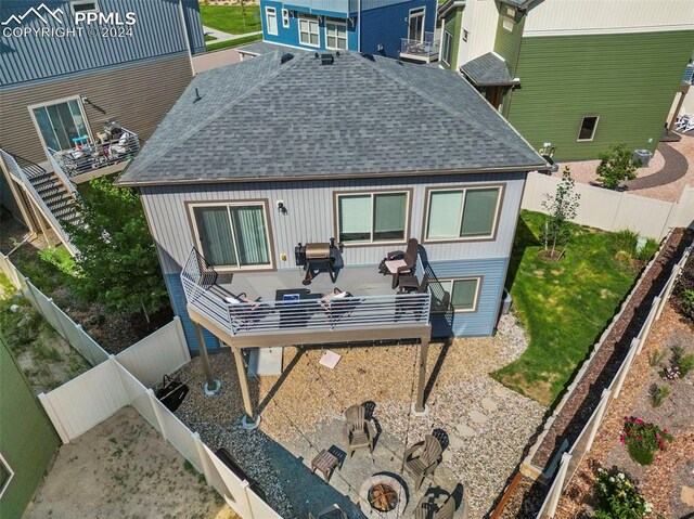 rear view of house with a wooden deck and a patio area