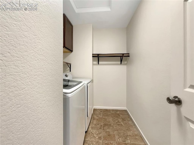 washroom with tile patterned flooring, cabinets, and washer and dryer