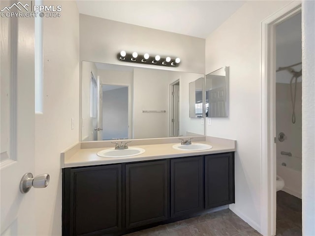 full bathroom with tile patterned flooring, washtub / shower combination, vanity, and toilet