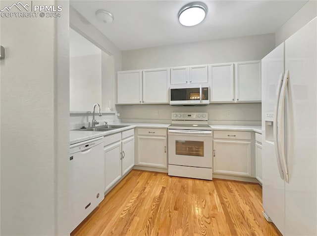 kitchen featuring sink, white appliances, white cabinetry, and light wood-type flooring