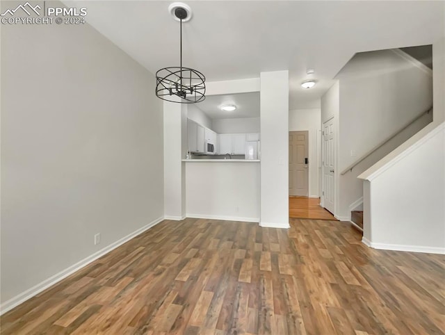 interior space with wood-type flooring and an inviting chandelier