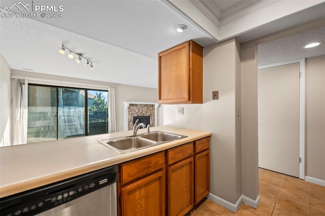 kitchen with crown molding, a textured ceiling, stainless steel dishwasher, and sink